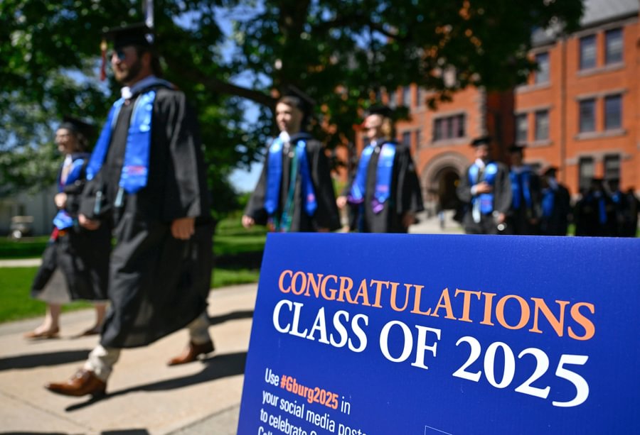 Graduates walk past Glatfelter Hall on their way to Commencement.