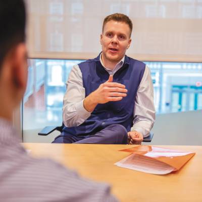 An image of an alumni talking to a student